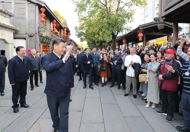 3月22日至25日，中共中央總書記、國家主席、中央軍委主席習(xí)近平在福建考察。這是24日下午，習(xí)近平在福州三坊七巷歷史文化街區(qū)考察時，向游客和市民招手致意。新華社記者 鞠鵬 攝